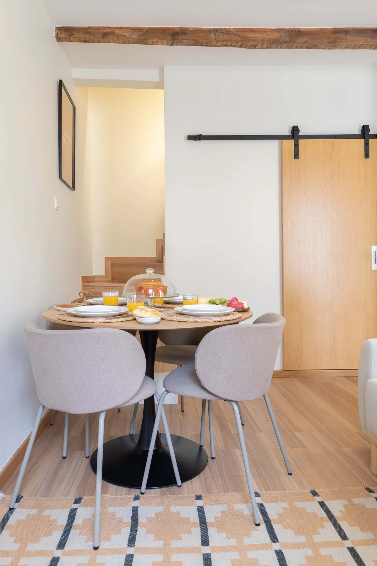 Comedor con una mesa redonda y asientos tapizados.