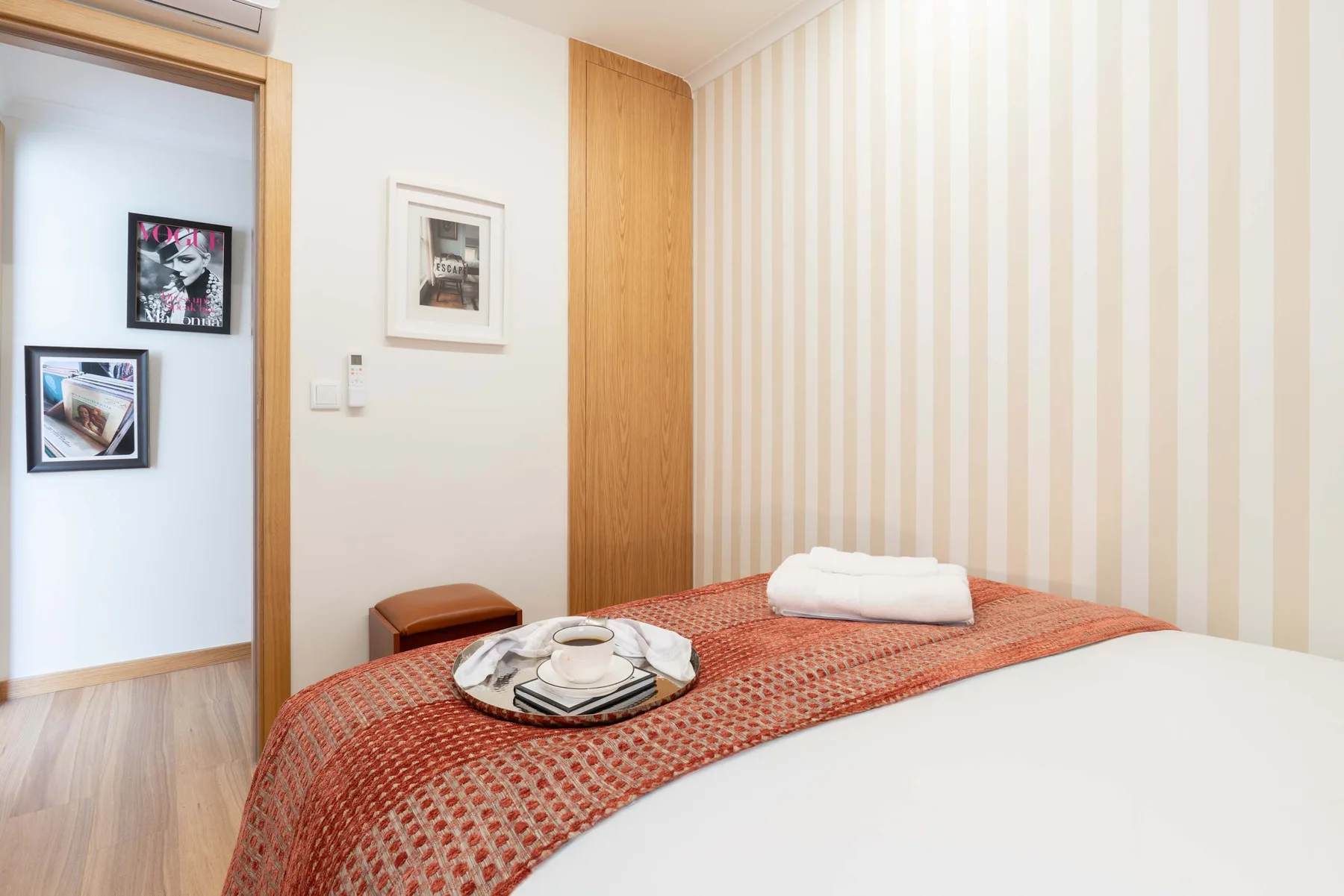 Un dormitorio con la cama arreglada y toallas dobladas.
