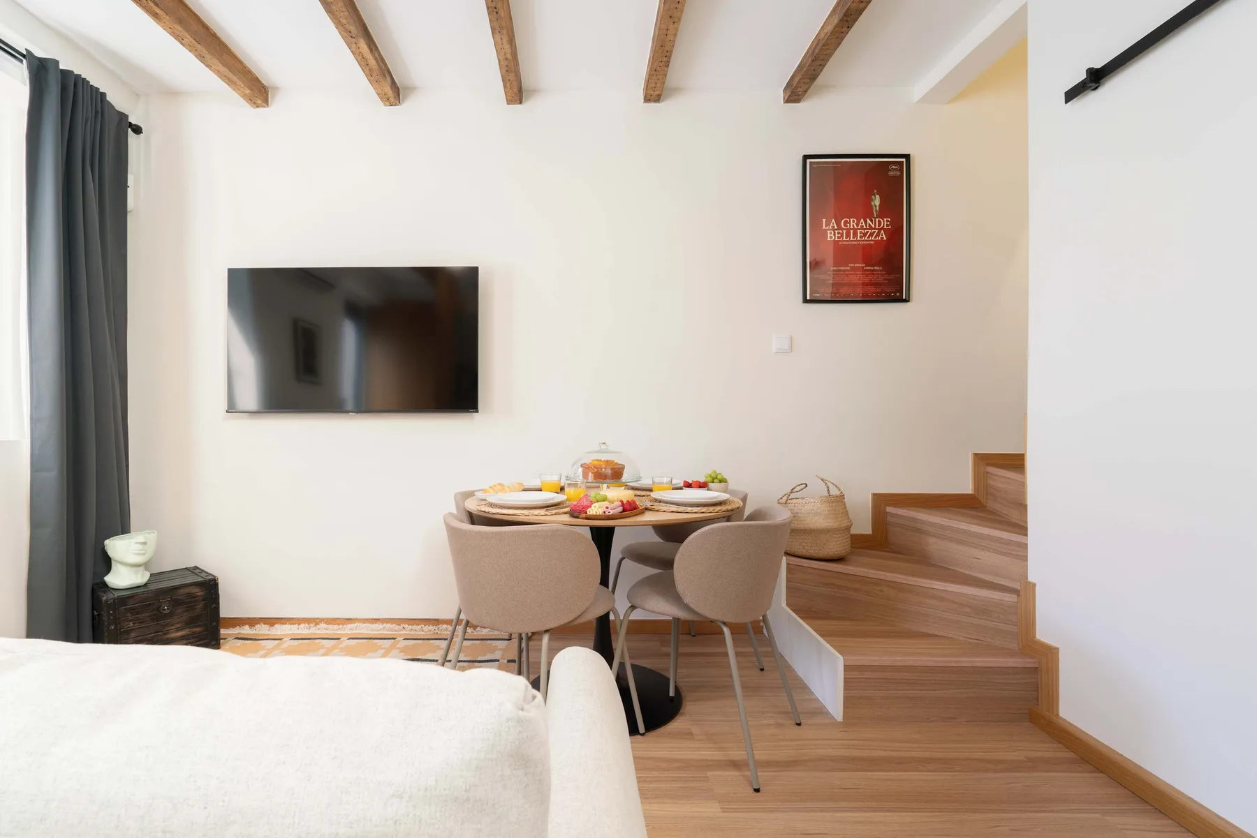 Comedor con una mesa y sillas junto a una plataforma de madera elevada.