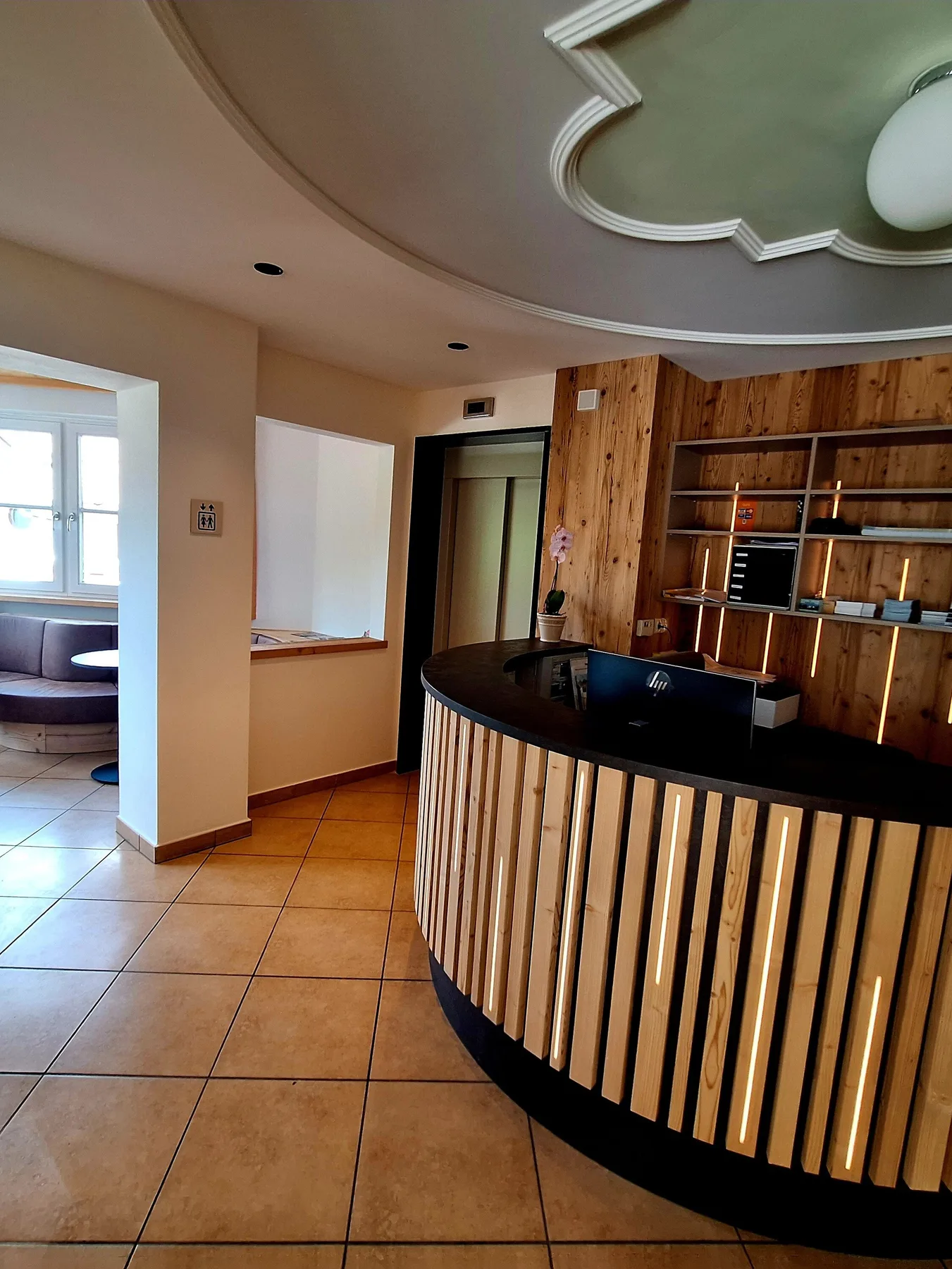 Representative hotel space: A curved reception counter stands in front of a wood-paneled wall.