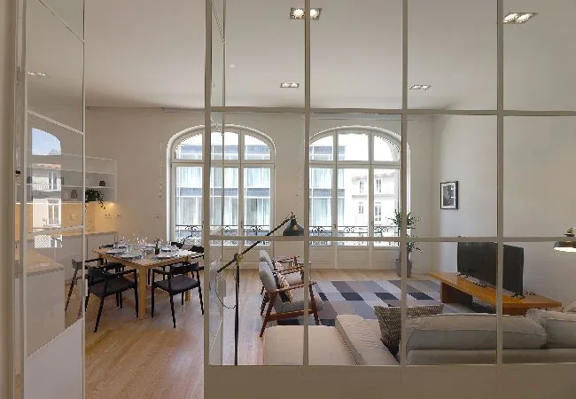 An open-plan living and dining area with large arched windows.