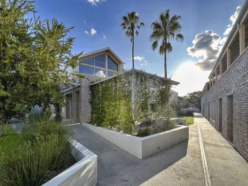 Espacio representativo del hotel: Un sendero exterior ajardinado bordea un edificio moderno.