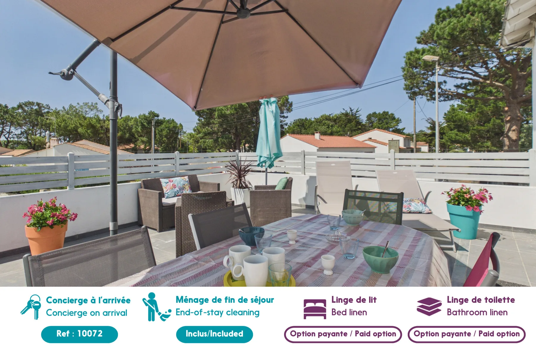An outdoor patio with a dining table and seating beneath a large umbrella.