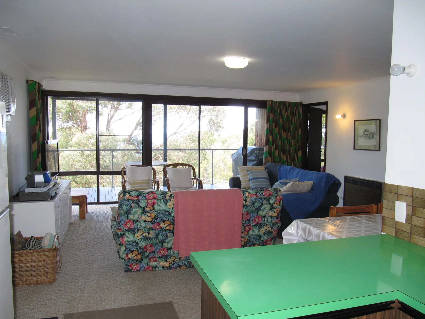Living room with seating arranged beside large windows overlooking trees.