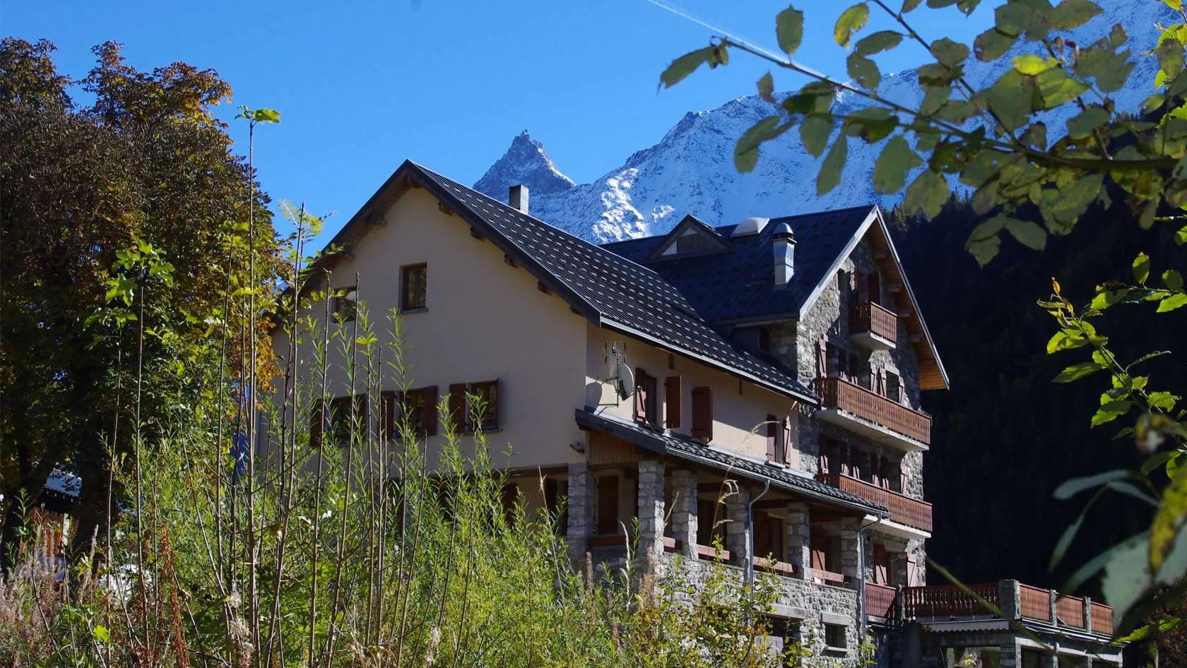 Espacio representativo del hotel: Un alojamiento de montaña con balcones se encuentra bajo un pico nevado.