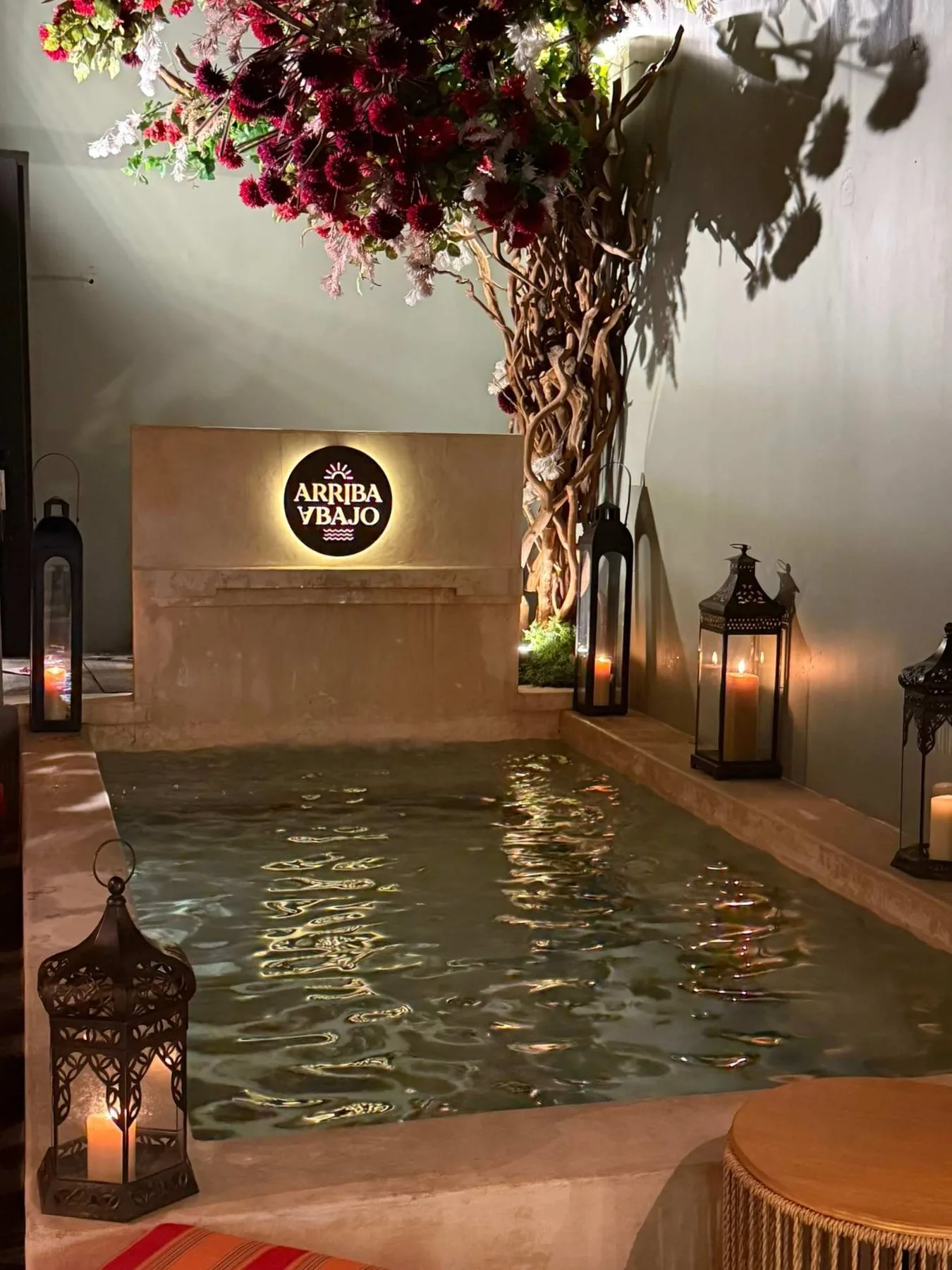 Shared amenity: A small illuminated pool sits beneath a flowering tree, with lanterns around it.