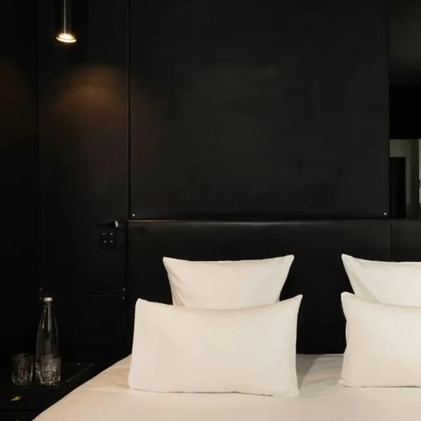 Representative hotel space: A dark bedroom with white pillows on the bed.