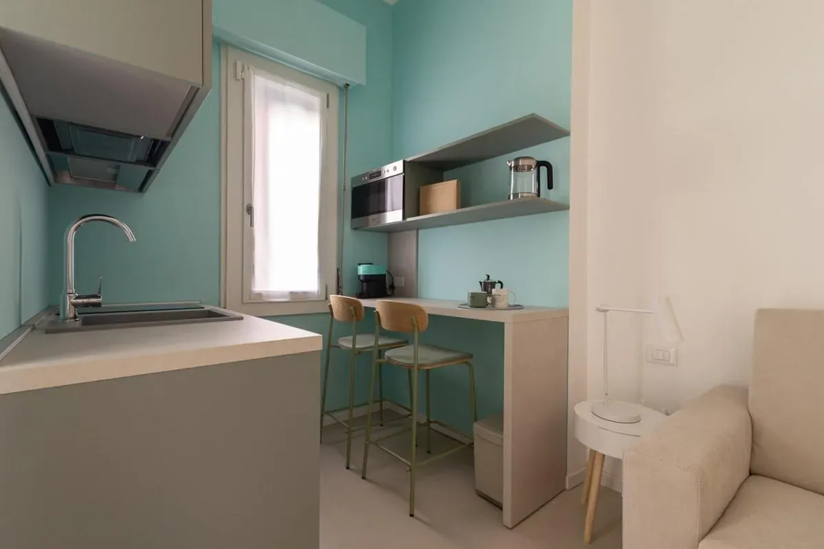 Una cocina compacta con una barra, taburetes y una ventana.