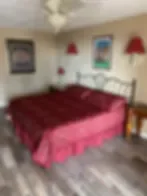 Representative hotel space: A bedroom with a bed covered in red bedding.