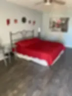 Representative hotel space: A bedroom with a red bed and a framed picture on the wall.