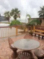 Representative hotel space: Outdoor patio seating surrounds a round table beside a railing and potted plants.