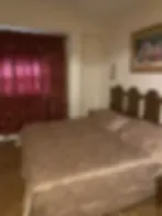Representative hotel space: A bedroom with a bed beside a window covered by dark curtains.