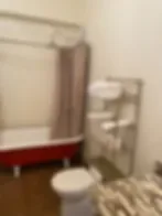 Representative hotel space: A bathroom with a bathtub and a toilet beside a small sink.