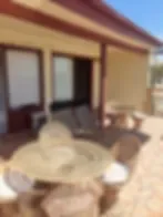 Representative hotel space: An outdoor patio with a round table and seating beside the building.
