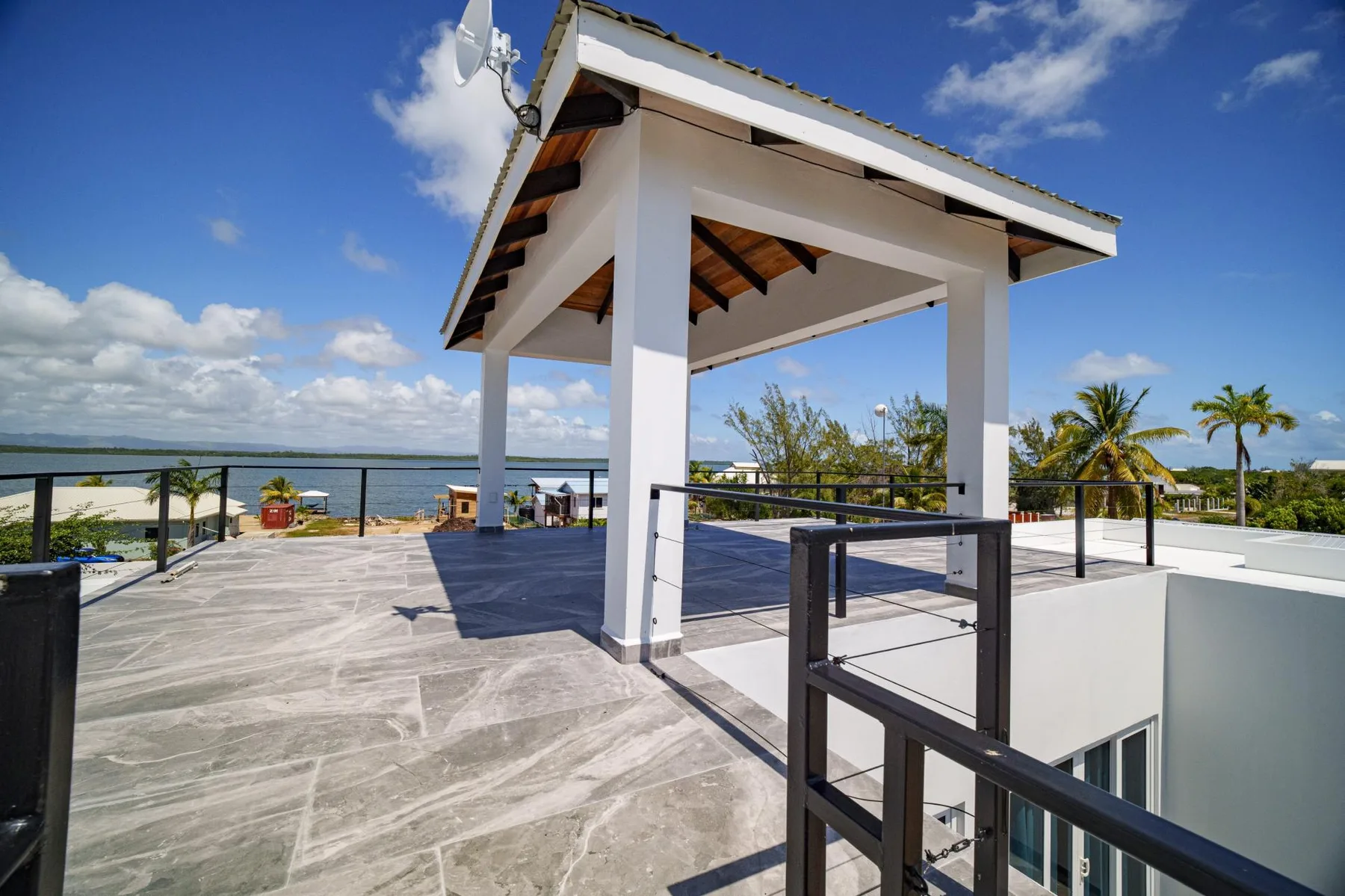 An open rooftop terrace with a covered pavilion overlooks the water.