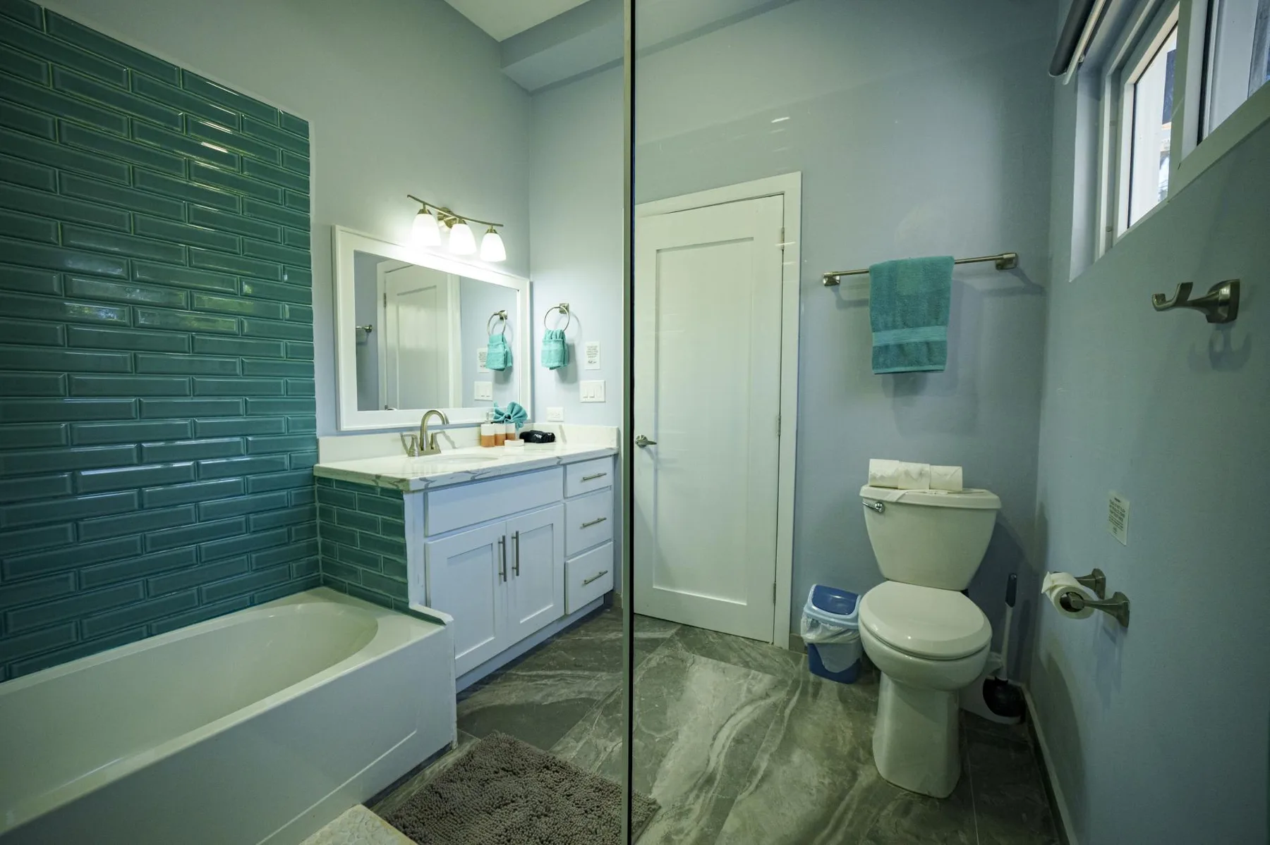 A bathroom with a bathtub, vanity, and toilet.