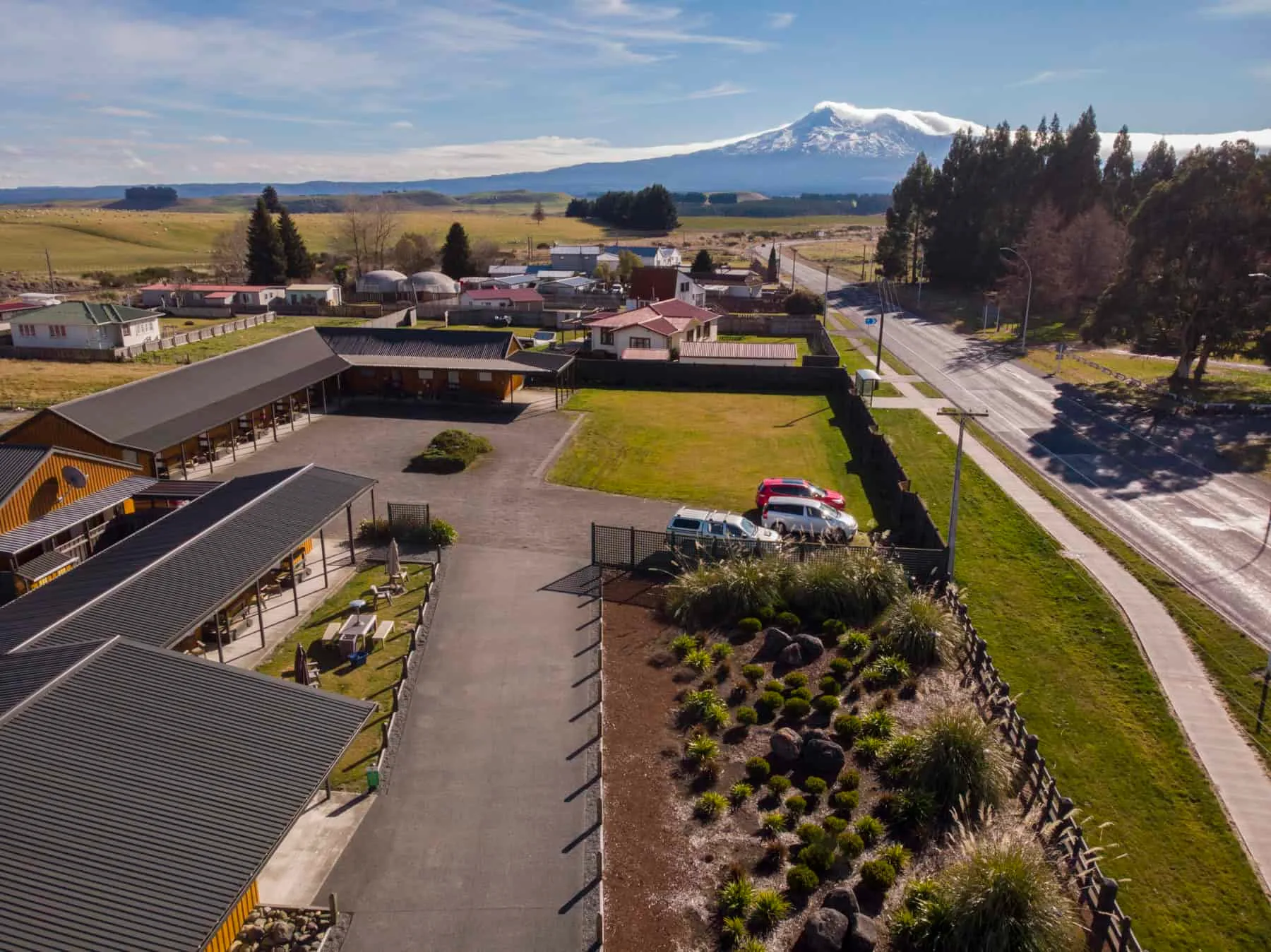 Representative hotel space: An aerial view of a roadside complex with landscaped grounds and a mountain in the distance.
