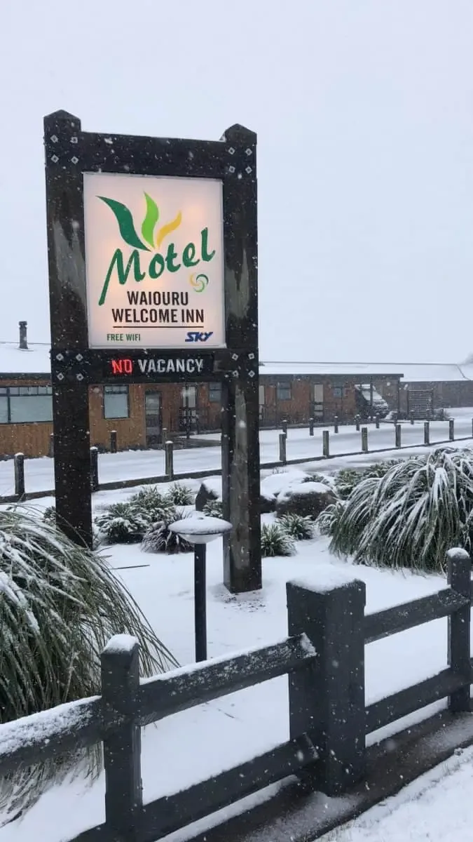 Representative hotel space: A roadside motel sign stands beside a snow-covered entrance.