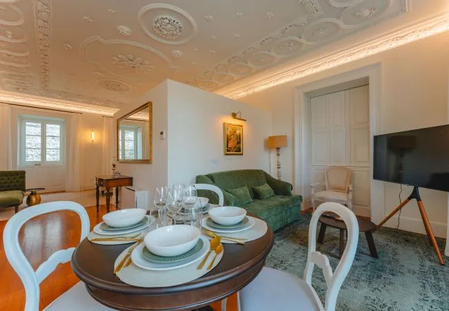 Una sala de estar con una mesa de comedor puesta con platos y vasos.