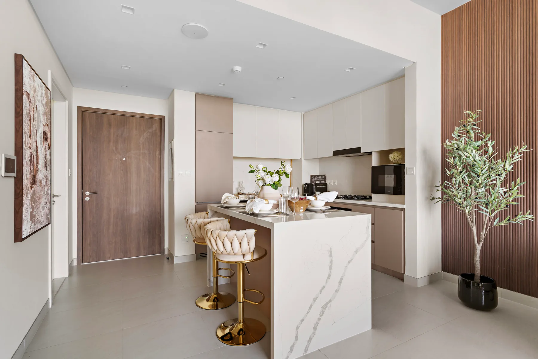 A modern kitchen with a marble island and bar seating.