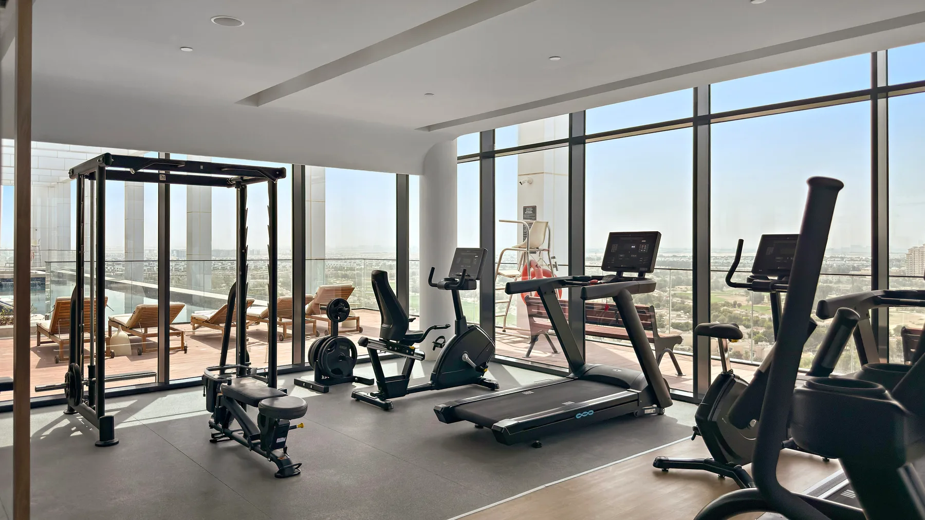 Shared amenity: A gym with exercise equipment beside large windows.