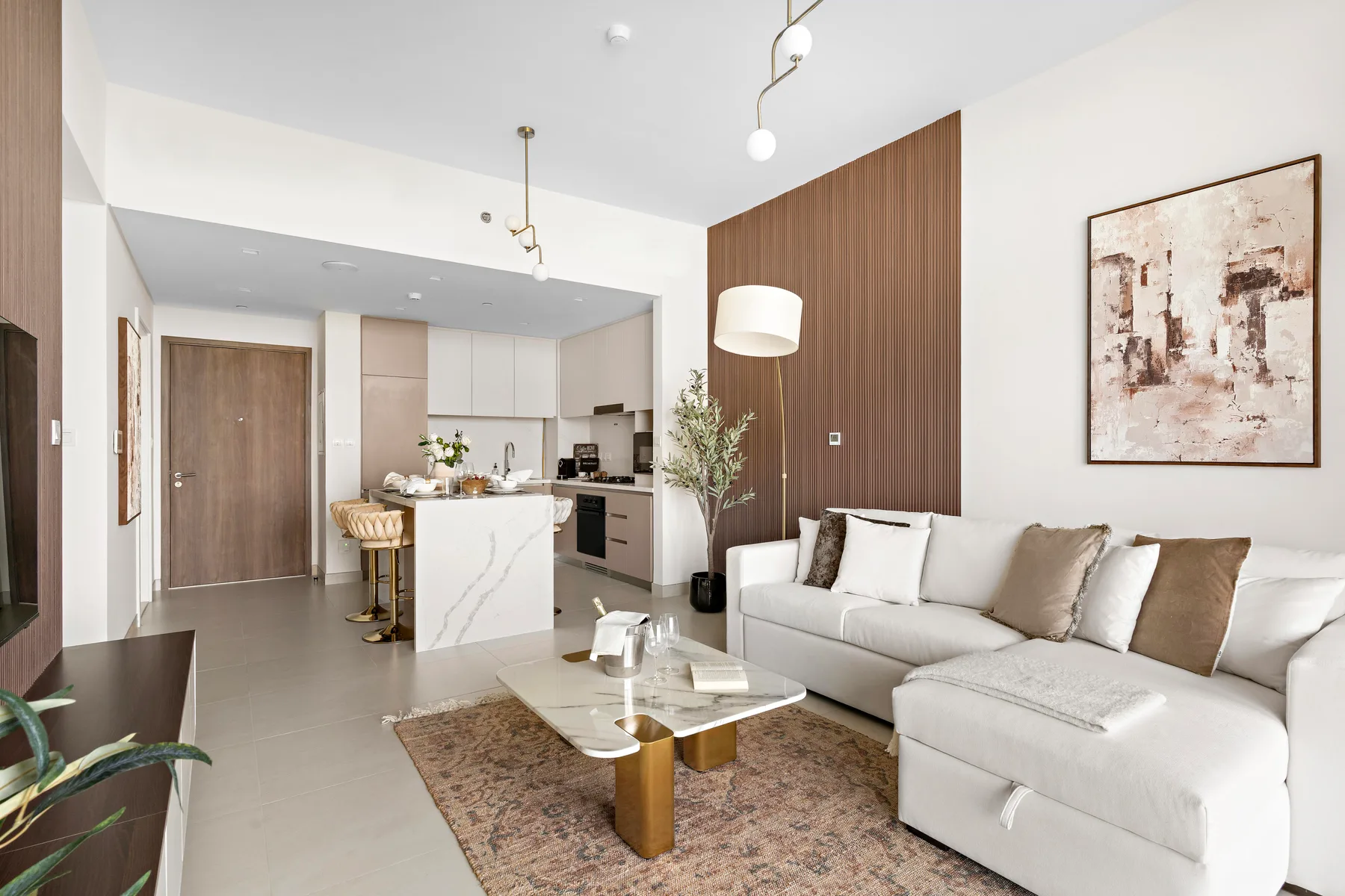 A bright living room with a sectional sofa and an open kitchen.