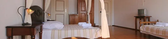Espacio representativo del hotel: Un dormitorio con dos camas y una pequeña mesa junto a ellas.