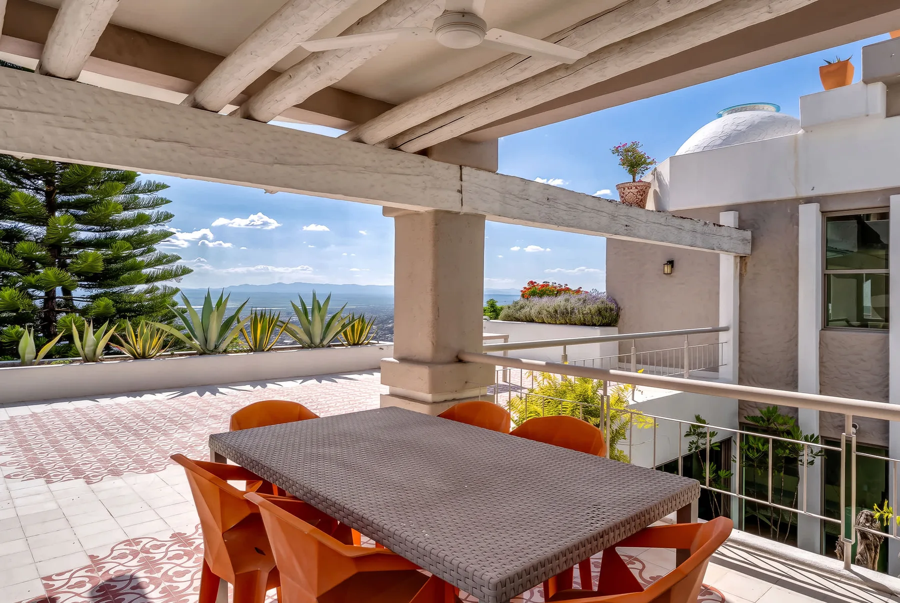 A covered outdoor dining area opens onto a terrace with ocean views.