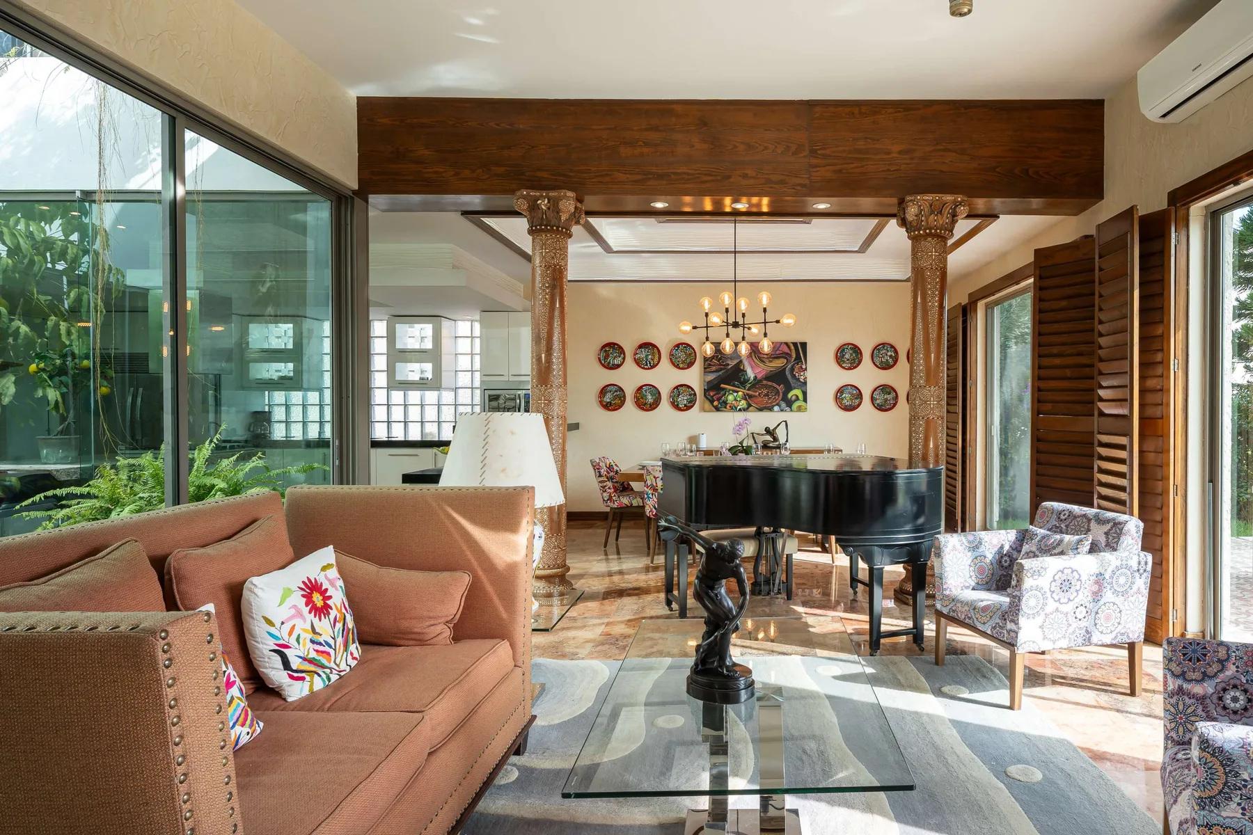 A bright living room with seating and a grand piano.