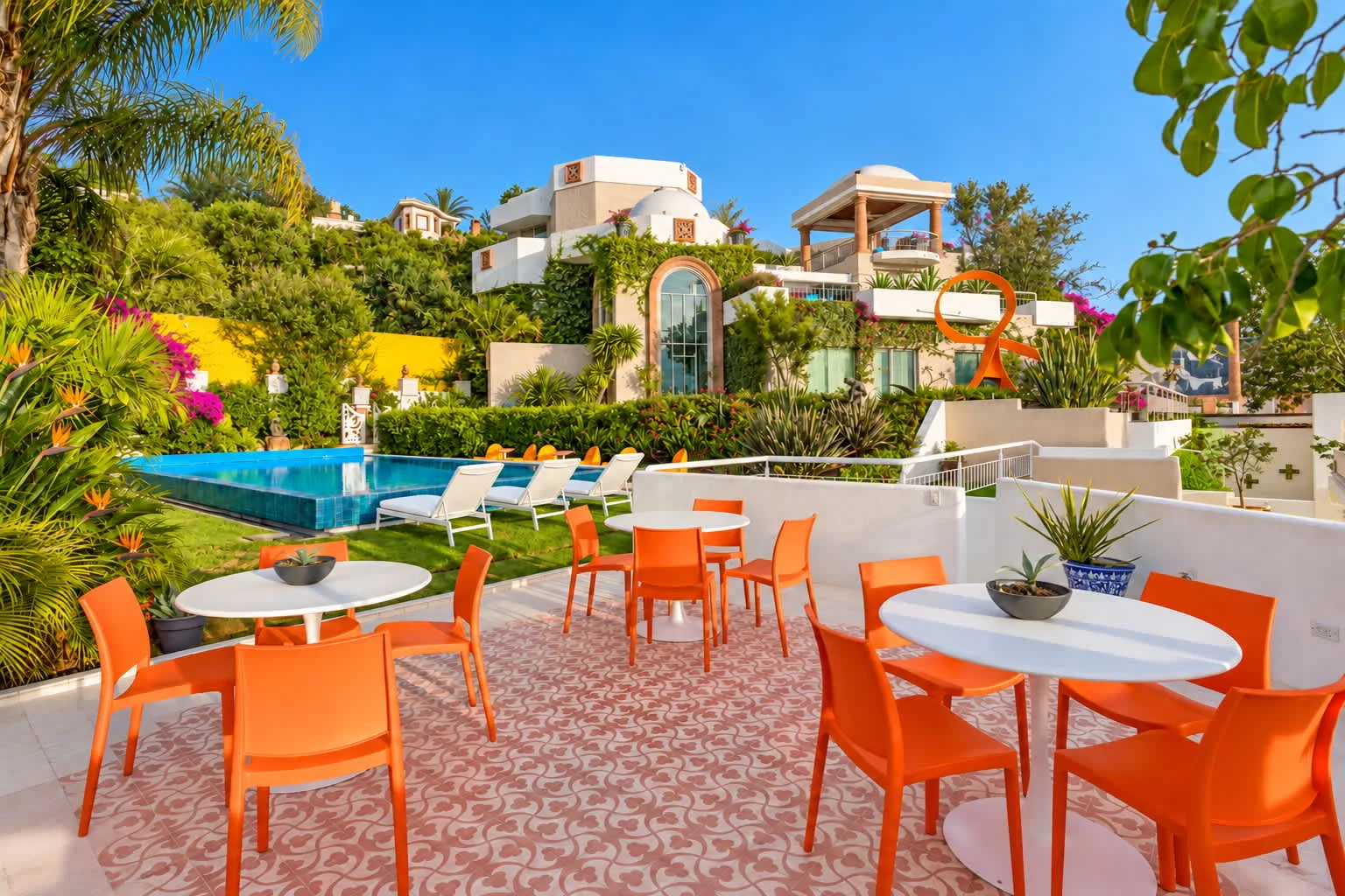 Shared amenity: Outdoor patio with dining tables and seating beside a swimming pool.