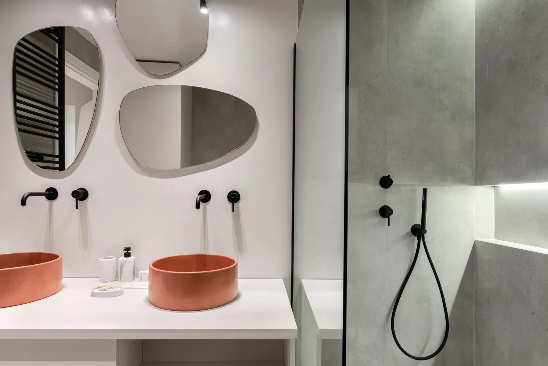 A modern bathroom with two vessel sinks and a walk-in shower.