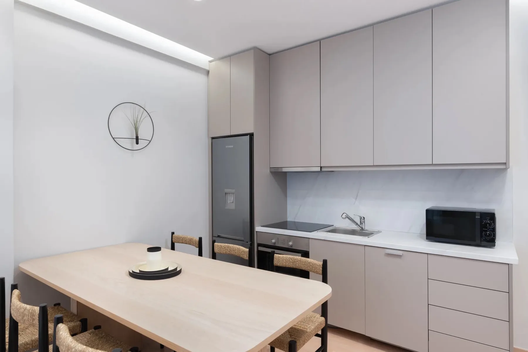 A dining area with a table beside a compact kitchen.