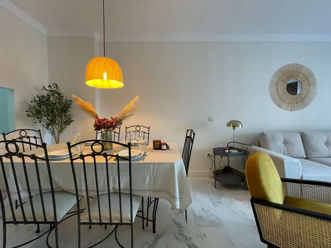 A dining area with a set table and a seating area beside it.