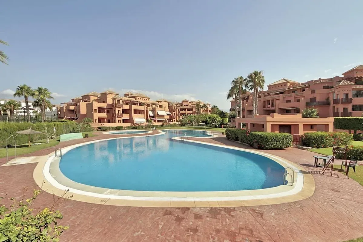 Shared amenity: A swimming pool sits among landscaped grounds and apartment buildings.