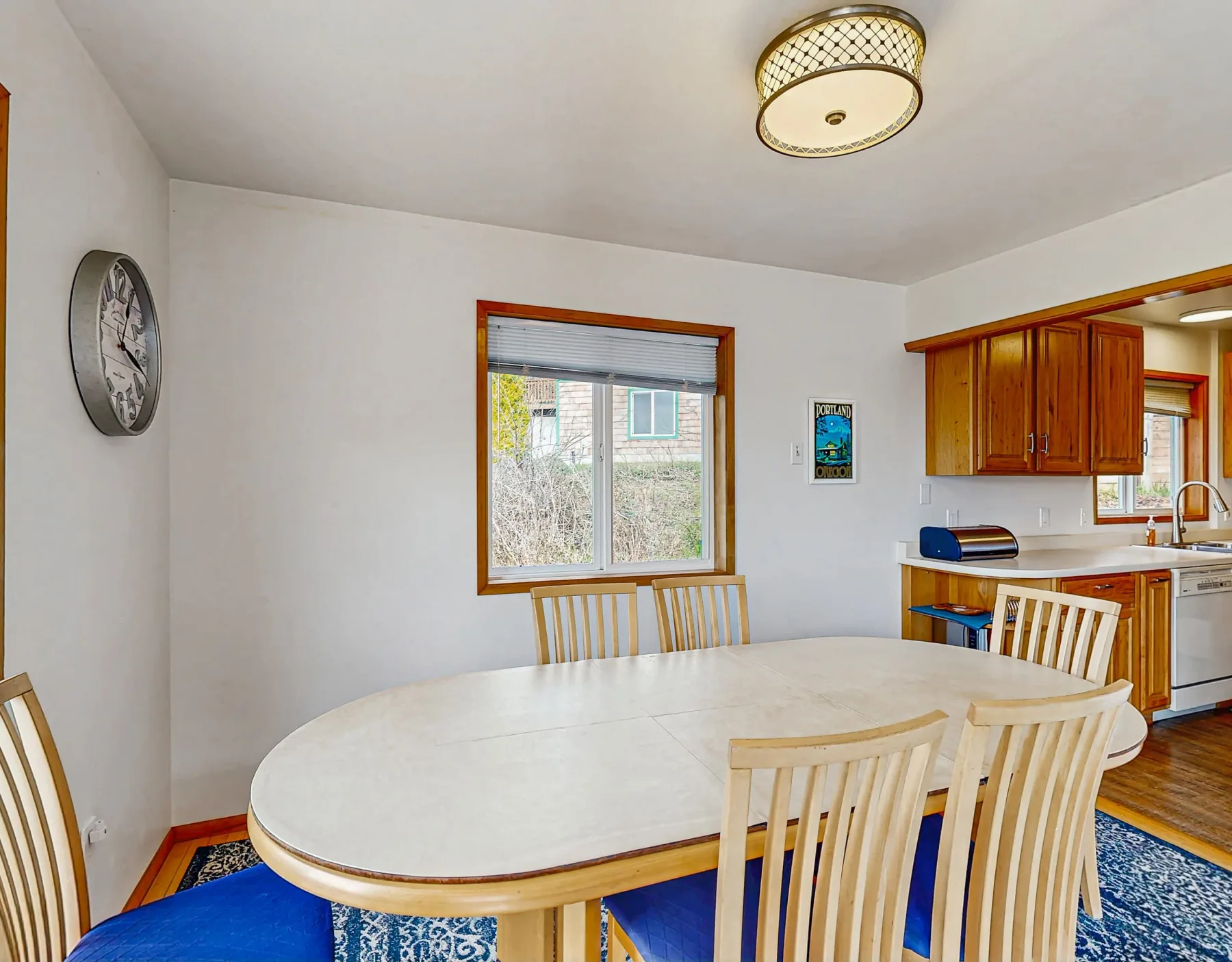 A dining area with a large table and chairs beside a kitchen.