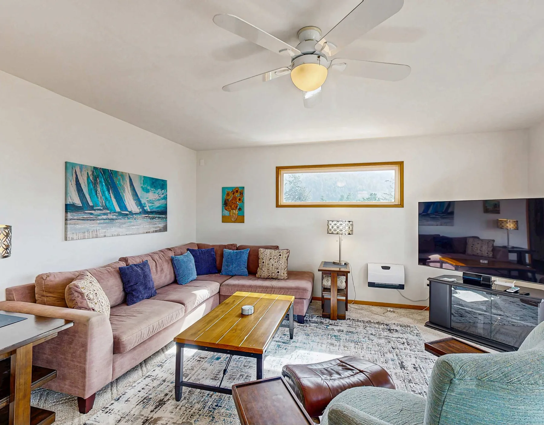 A living room with seating, a coffee table, and a television.