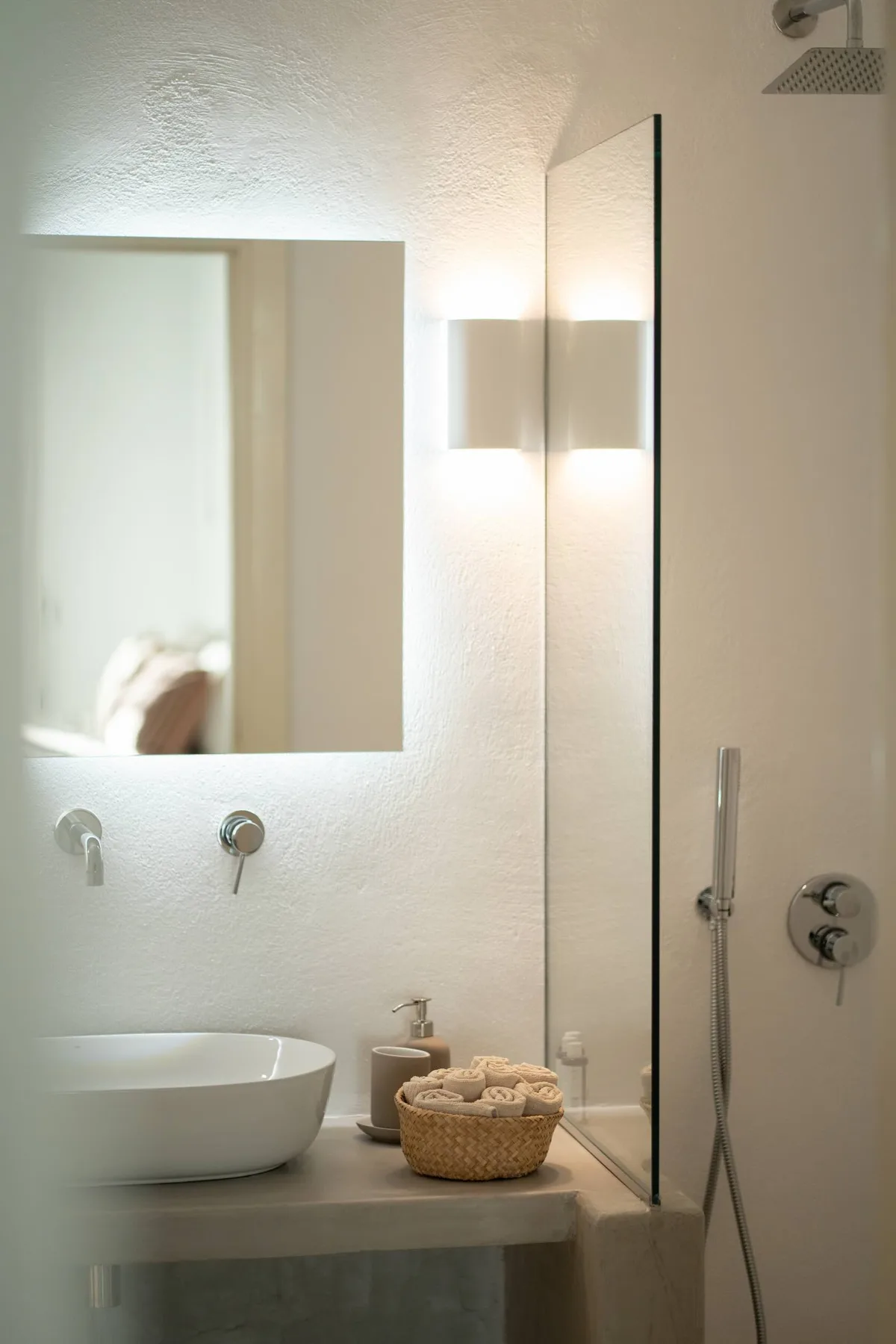 A bathroom vanity with a basin sits beside a glass-paneled shower.