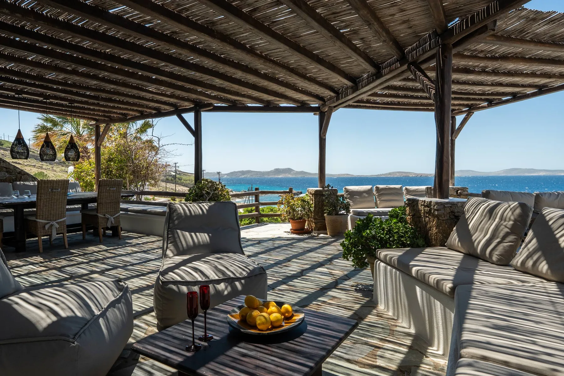 A shaded outdoor seating area overlooks the sea.