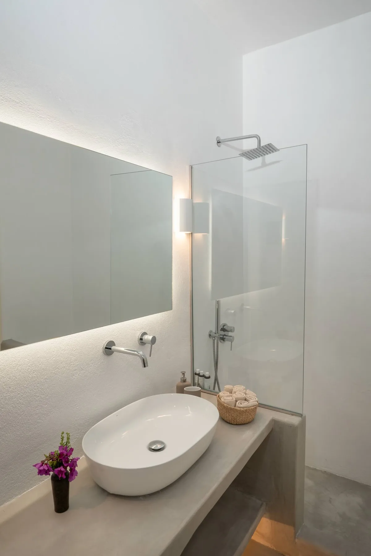 A modern bathroom with a vessel sink and glass-enclosed shower.