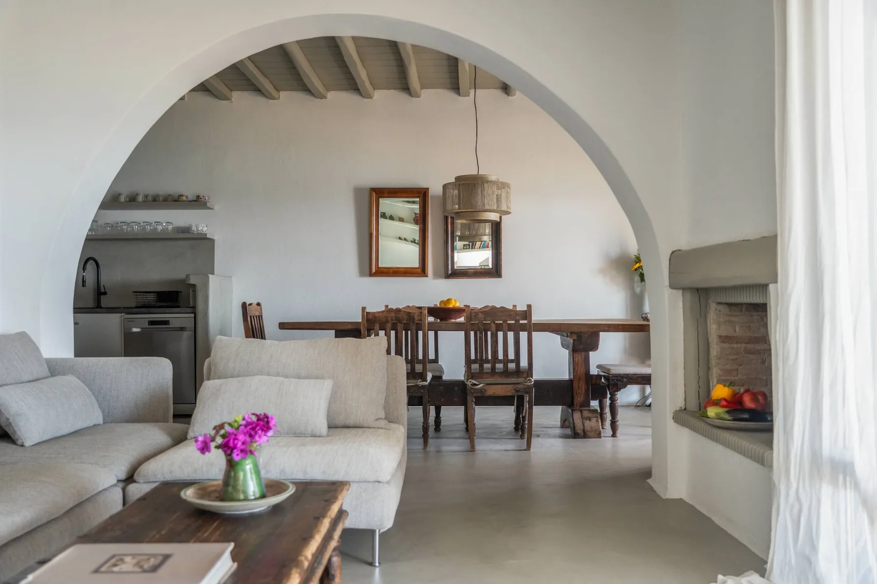 A living and dining area with seating, a table, and a fireplace.
