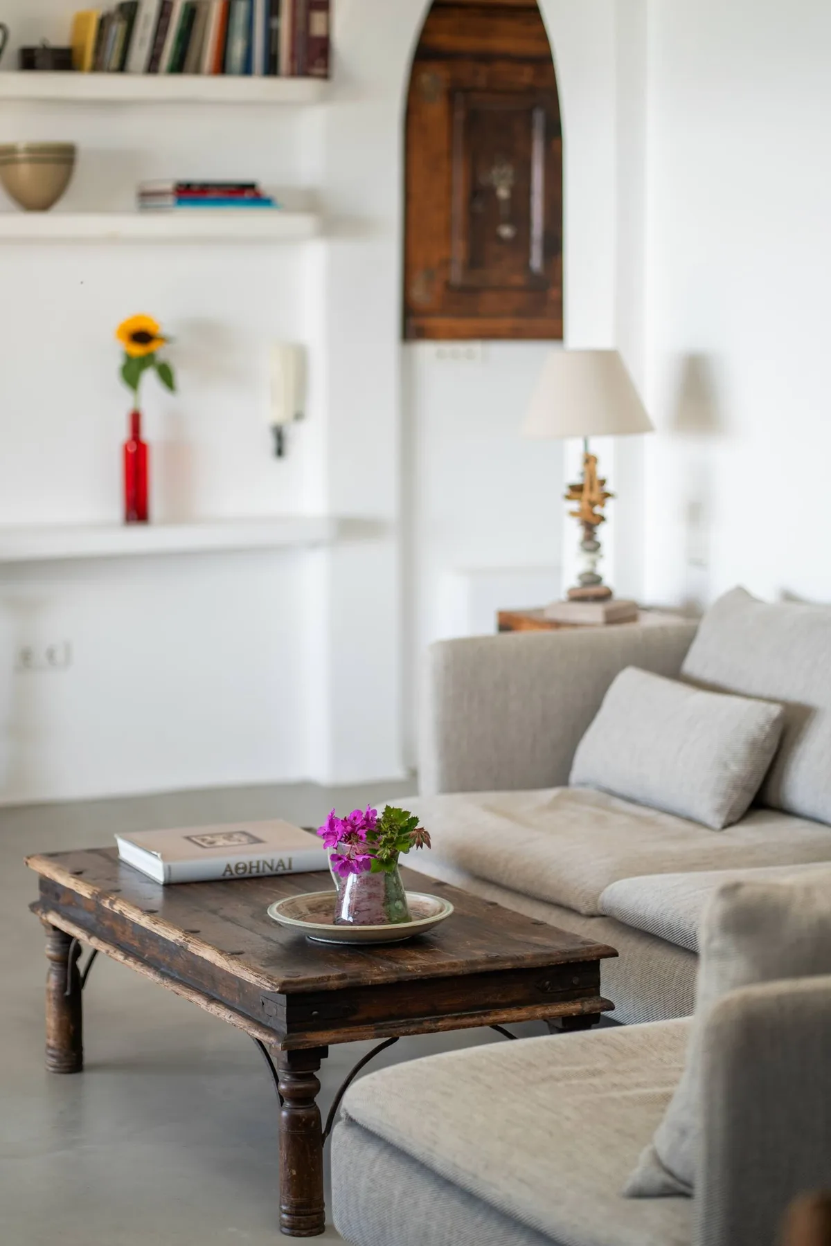 A bright living room with a gray seating area and a wooden coffee table.