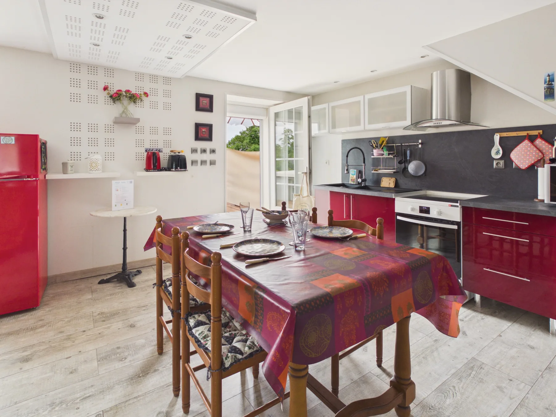 Un comedor con una mesa preparada para comer junto a una cocina.