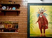 Representative hotel space: A warm-toned interior wall displays shelves and a colorful framed artwork.