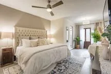 A bedroom with a large bed and a ceiling fan.