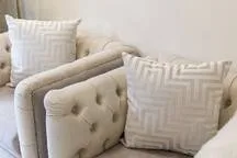 A light-colored seating area with patterned cushions.