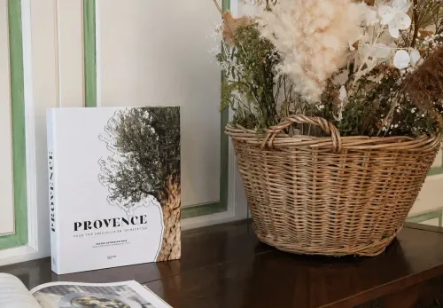 Espacio representativo del hotel: Una mesa muestra un libro junto a una cesta de mimbre con flores secas.
