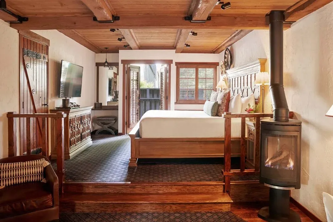 Representative hotel space: A bedroom with a raised bed and a wood-burning stove.