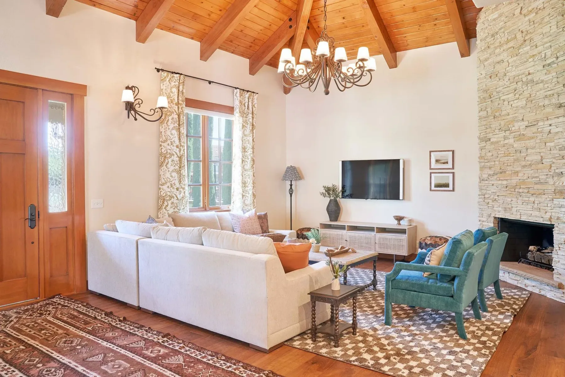 Representative hotel space: A living room with seating arranged around a television and fireplace.