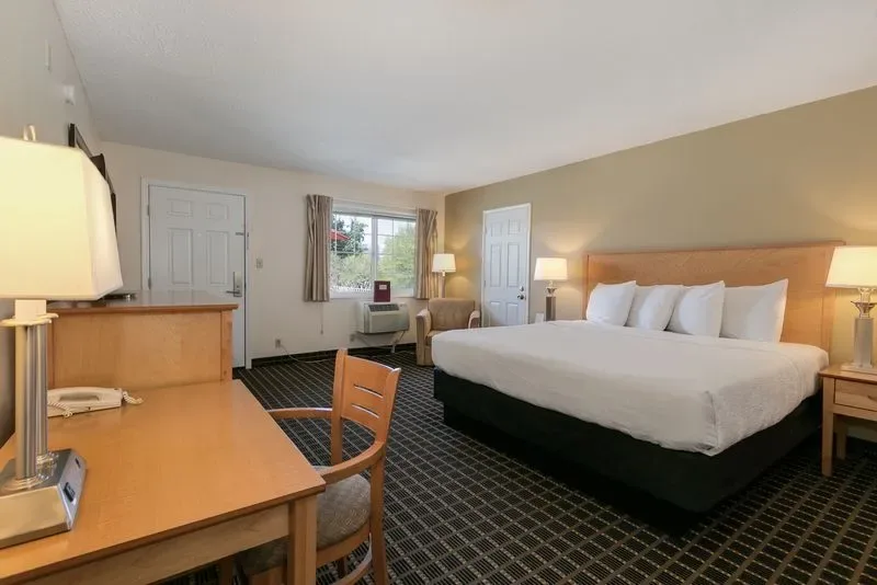 Representative hotel space: A hotel guest room with a large bed, desk, and window.