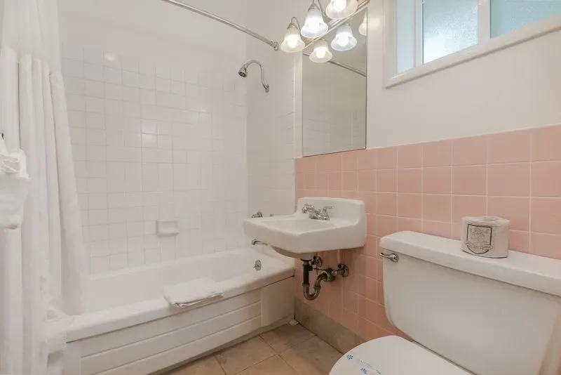 Representative hotel space: A bathroom with a bathtub, wall-mounted sink, and toilet.